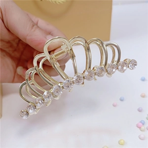 Dettaglio di un fermaglio per capelli dorato a forma di corona con strass luminosi