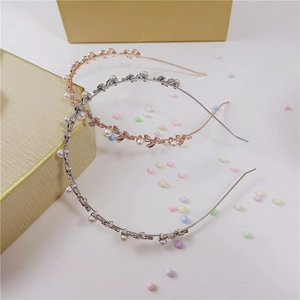 Detailed shot of rose gold and silver metal headbands with leaf accents and pearls