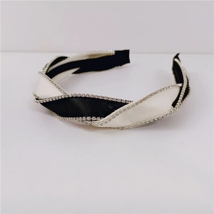Detail of twisted black and white satin headband with sparkling rhinestone edges