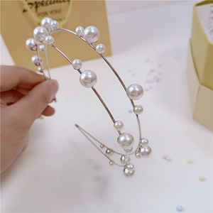 Dettaglio di elegante cerchietto a doppio strato con perle e confezione regalo raffinata