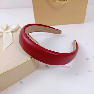 Détail d'un serre-tête en similicuir rouge rembourré avec texture épaisse et doublure