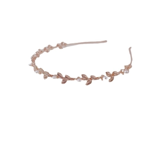 Elegant rose gold metal leaf headband with white pearls for women on white background