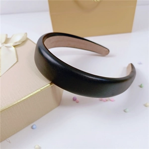 Détail d'un serre-tête large en cuir PU noir avec une doublure en velours beige