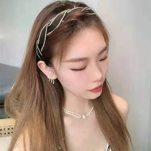 Sparkling rhinestone headband with wave-shaped crossover design on a narrow black base