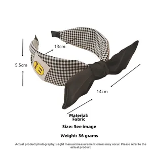 Détail du serre-tête à carreaux avec nœud noir, patch smiley jaune et dimensions précises