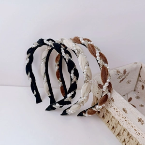 Detailed view of velvet braided headbands with pearls and rhinestones in black, beige and brown