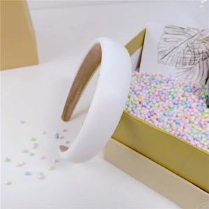 Détail d'un serre-tête rembourré en similicuir blanc avec doublure en velours kaki
