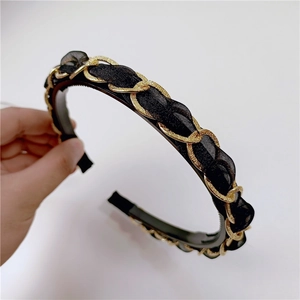 Detail of vintage gold metal chain and black ribbon woven on a non-slip hairband