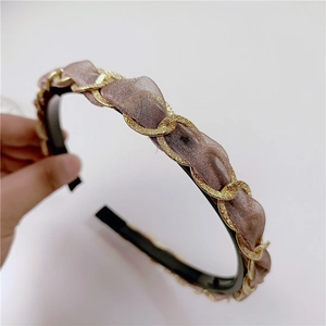 Close-up of vintage golden chain and sheer purple chiffon fabric braided headband