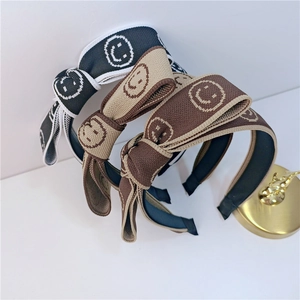 Trois bandeaux tricotés à nœuds en noir, kaki et café avec des motifs smiley blancs