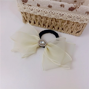 Détail du nœud en organza blanc avec ornement de perles rétro et strass étincelants