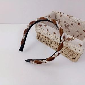 Detail of vintage velvet headband with white faux pearls and sparkling rhinestone chains