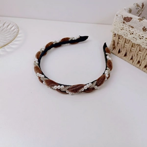 Detailed macro of brown velvet braided headband with white pearls and sparkling rhinestones