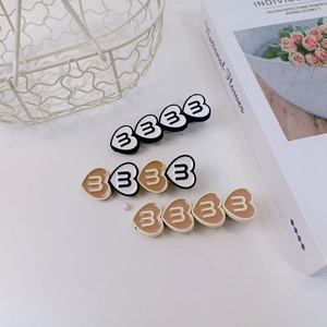Détail des barrettes à cheveux en forme de cœur en résine mate avec motif lettre stylé