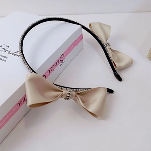 Detail of Korean style headband featuring champagne satin bows and sparkling rhinestones