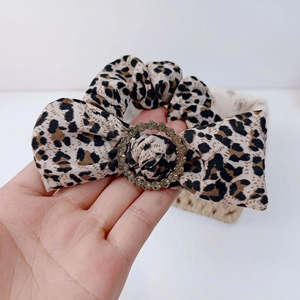 Detail of leopard print bow hair scrunchie with sparkling crystal ring buckle