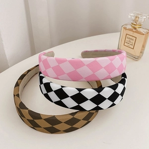 Close-up of three colorful checkered padded headbands with thick fabric and non-slip lining