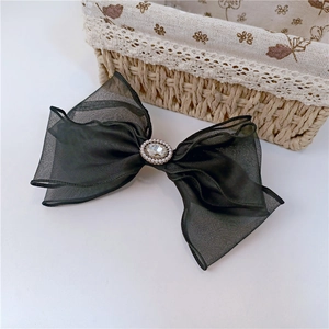 Détail d'une grande pince à cheveux papillon en organza noir avec strass et perles