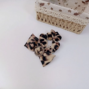 Detail of leopard print satin hair tie featuring a sparkling silver rhinestone center