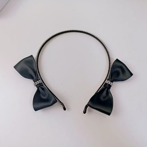 Detail of black silk satin bow headband with sparkling rhinestones and metal band