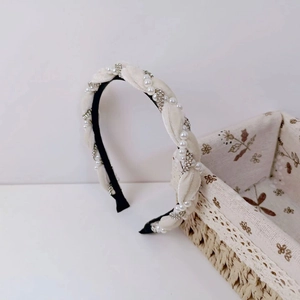 Braided velvet headband featuring alternating pearls and rhinestones in white