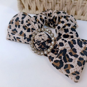 Leopard print bow scrunchie with rhinestone buckle for stylish hair styling and accessory