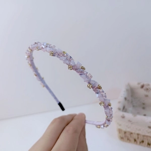 Détail d'un serre-tête fait main en cristal violet avec des accents de strass dorés brillants