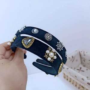 Detailed close-up of velvet headband with faux pearls, rhinestones and gold star accents