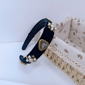Detail of baroque black velvet headband featuring star pearls and a grey gemstone inlay