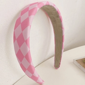 Close-up of pink and white diamond pattern fabric headband with soft suede inner lining