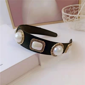Close-up of Baroque velvet headband featuring faux pearls in golden floral metal frames