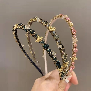 Detailed view of hand-encrusted crystal headbands with gold beads in three elegant colors