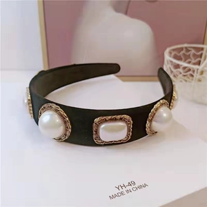 Close-up of velvet headband featuring large vintage pearls in golden filigree settings