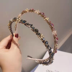Detail of luxury gold headbands with sparkling pink and dark green crystals in a set