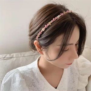 Close-up of elegant gold headband featuring pink crystals and beads on female model