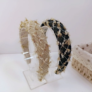 Detail of tweed headband with metallic sequins and golden fringe in black and beige