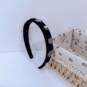Close-up of velvet headband featuring intricate rhinestone flowers and white pearls