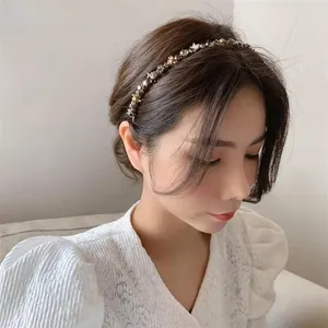Close-up detail of champagne gold rhinestone headband worn on dark brown hair
