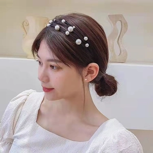 Detail showing the elegant triple-layer pearl headband worn by a model in a minimalist room