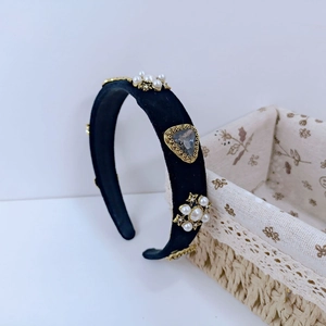 Detailed side view of baroque velvet headband with pearls, golden stars and grey gem