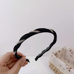 Detail of black braided headband featuring spiral silver rhinestone chain decoration