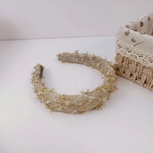 Detail of French chic tweed headband with gold metallic fringe and diamond lattice pattern
