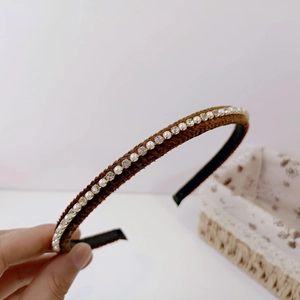 Detail of brown plush headband featuring elegant faux pearls and sparkling rhinestones