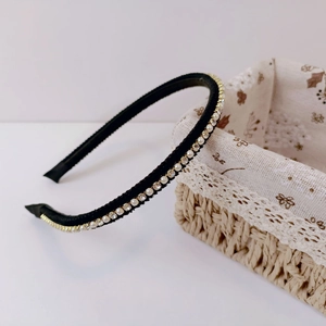 Detailed macro view of the non-slip inner teeth and pearl embellishments on the headband