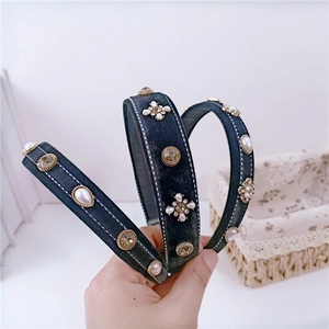 Vintage dark gray velvet headband with pearls and rhinestones shown in hand