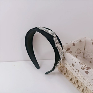 Close-up of black velvet padded headband with shiny silver rhinestone diagonal stripes