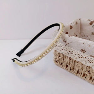 Detail shot of elegant cream velvet headband with faux pearls and rhinestones on a basket