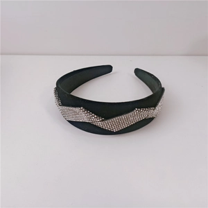 Detailed close-up of a black velvet headband with elegant wavy rhinestone crystal patterns