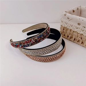 Detailed view of three colorful rhinestone headbands with non-slip lining on white background