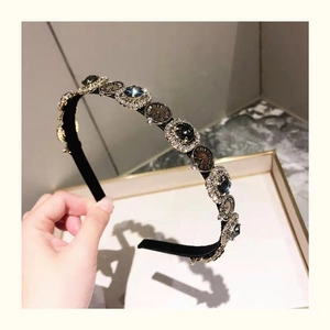 Detailed view of vintage headband with crystal rhinestones and embossed metal buttons